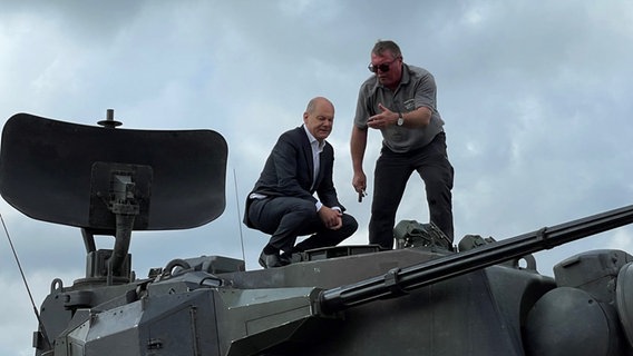 Bundeskanzler Scholz und Ausbildungsleiter Schoch stehen auf dem Turm eines Gepard-Panzers © NDR Foto: Christian Wolf