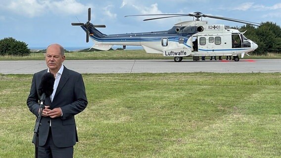 Bundeskanzler Olaf Scholz steht in Putlos vor einem Mikrofon, hinter ihm ein Helikopter der Luftwaffe Bundeskanzler Olaf Scholz steht in Putlos vor einem Mikrofon, hinter ihm ein Helikopter der Luftwaffe © NDR Foto: Christian Wolf