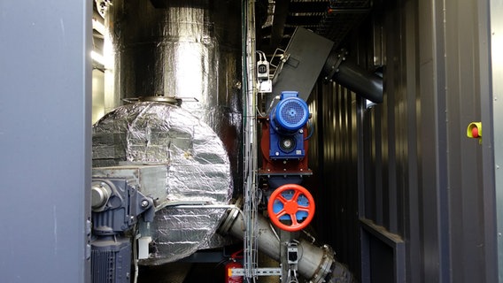 Der Reaktor der Pyrolyseanlage auf dem Kreiswirtschaftshof Rendsburg-Eckernförde steht, in alufarbenem Material eingewickelt, aufgestellt in einem Überseecontainer. © NDR Foto: Maja Bahtijarevic