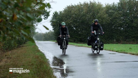 Ein Mann und eine Frau machen eine Radtour bei Regen. © NDR 
