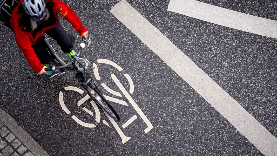 Auf einer Straße in Lübeck markiert ein Fahrradsymbol den Radweg. 