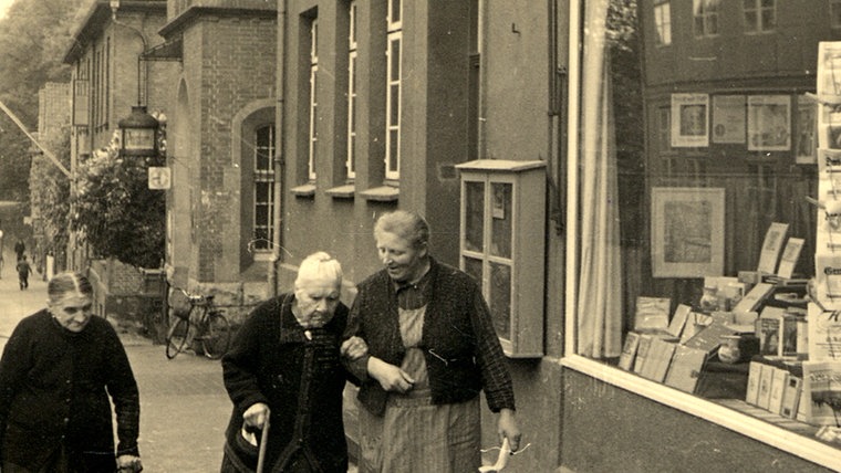 Drei ältere Frauen laufen an der Buchhandlung Weber im alten Ratzeburg vorbei. © Kreismuseum Ratzeburg