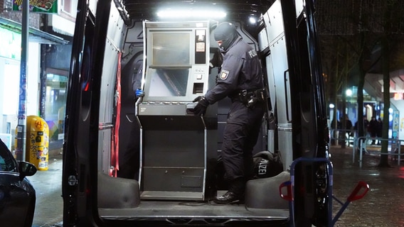 Polizeibeamte verstauen einen sichergestellten Spielautomaten. © Danfoto Foto: Daniel Friedrichs