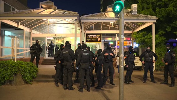 Mehrere Einsatzkräfte der Polizei stehen bei Nacht vor einem Gebäudekomplex bei einer Razzia in Pinneberg. © TeleNewNetwork 