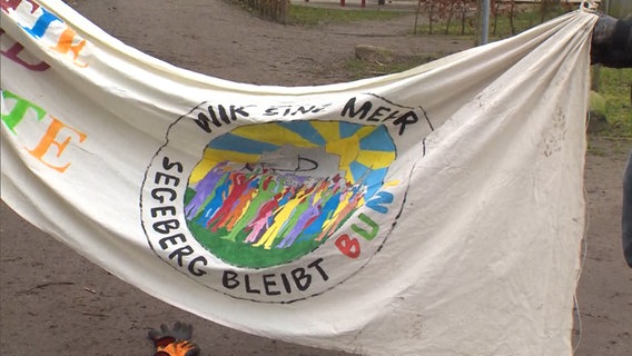 Auf einem Banner steht "Wir sind mehr - Segeberg bleibt bunt".  
