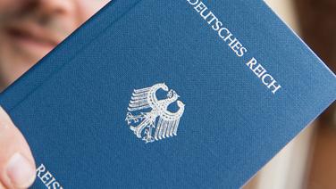 Ein Mann hält ein Heft mit dem Aufdruck "Deutsches Reich Reisepass" in der Hand. © dpa-Bildfunk Fotograf: Patrick Seeger