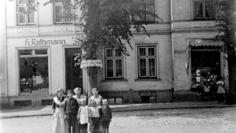 Eine historische Aufnahme eines Gebäudes der Firma "H. Rathmann", vor dem eine Personengruppe steht. © Stadtarchiv Reinbek/Dr. Carsten Walczok