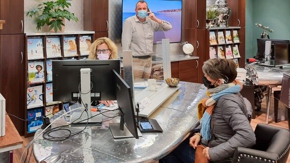 Eine Kundin sitzt im Reisebüro Vanselow.im Kieler Citti-Park und wir von einer Mitarbeiterin beraten. © NDR Foto: Julian Marxen