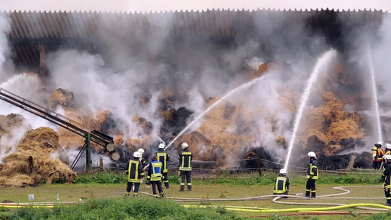 Mehrere Feuerwehrleute löschen einen Brand in einer qualmenden Scheune. © TV-Produktion Friederichs Foto: Daniel Friederichs