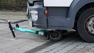 Ein E-Scooter liegt unter einem Lkw begraben. © picture alliance 