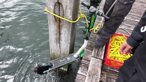Ein im Hafenbecken versenkter Elektroroller wird aus der Kieler Förde geborgen © NDR Foto: Screenshots