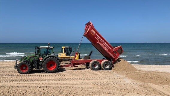 Traktor mit Anhänger schüttet Sand auf Strand in Heiligenhafen © NDR Foto: Friederike Schneider