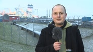 NDR-Reporter Jörn Zahlmann steht vor dem LNG-Terminal am Hafen Brunsbüttel. © NDR 