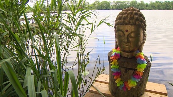 Eine Buddha-Figur steht an einem See in Löptin. © NDR 
