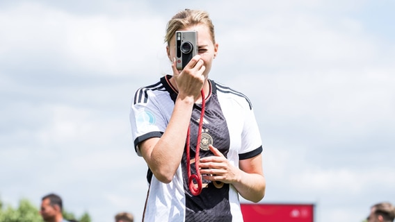 Laura Freigang mit einer Kamera in der Hand. © IMAGO / Beautiful Sports Foto: IMAGO / Beautiful Sports