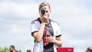 Laura Freigang mit einer Kamera in der Hand. © IMAGO / Beautiful Sports Foto: IMAGO / Beautiful Sports