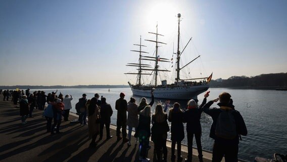 Angehörige und Freunde begrüßen die "Gorch Fock" beim Anlegen an der Mole im Marinestützpunkt Kiel-Wik. © dpa-Bildfunk Foto: Christian Charisius