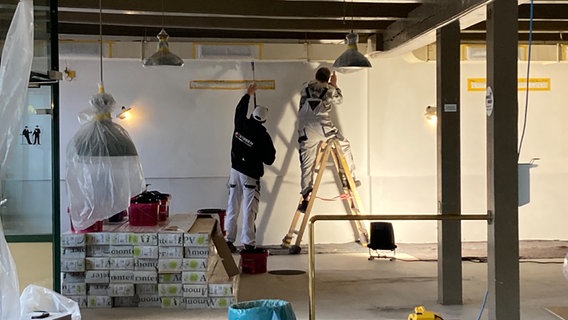 Zwei Arbeiter auf einer Baustelle in der Hansen Brauerei. © NDR Foto: Simone Mischke