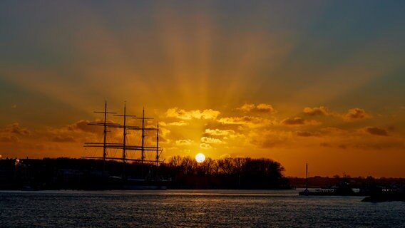 Die Sonne strahlt zur goldene Stunde über das Wasser in Travemünde. © Peter Karg Foto: Peter Karg