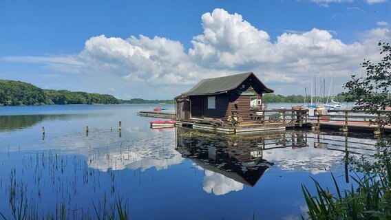 Ein Bootsverleihhaus steht nicht weit vom Ufer auf dem Wasser © Karin Bürger Foto: Karin Bürger