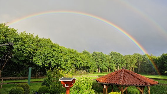 Ein vollständiger Regenbogen ist in einem Garten zu sehen © Hans Gustav Cymontkowski Foto: Hans Gustav Cymontkowski