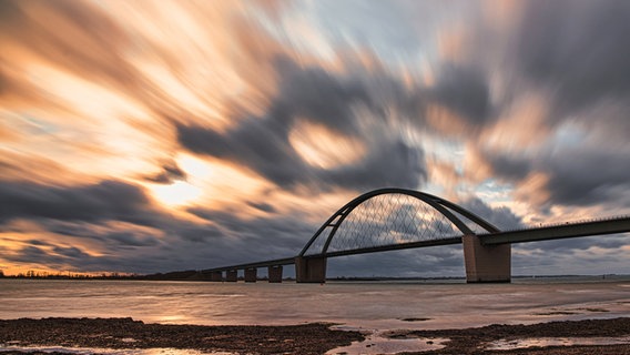 Die Fehmarnsundbrücke in dämmrigem Licht und Wolken am Himmel. © Ralf Horstmann Foto: Ralf Horstmann