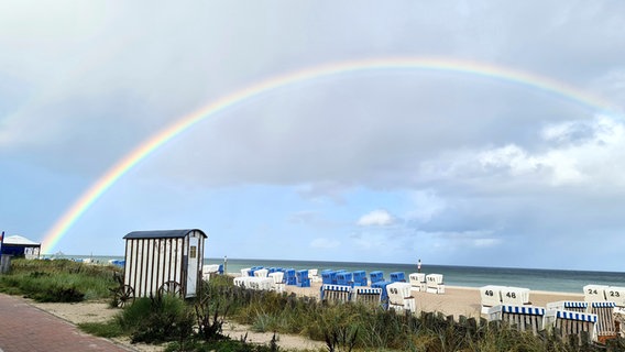 Ein Regenbogen über der Ostsee an einem Strand mit vielen Strandkörben. © Elisabeth Jaxa Foto: Elisabeth Jaxa