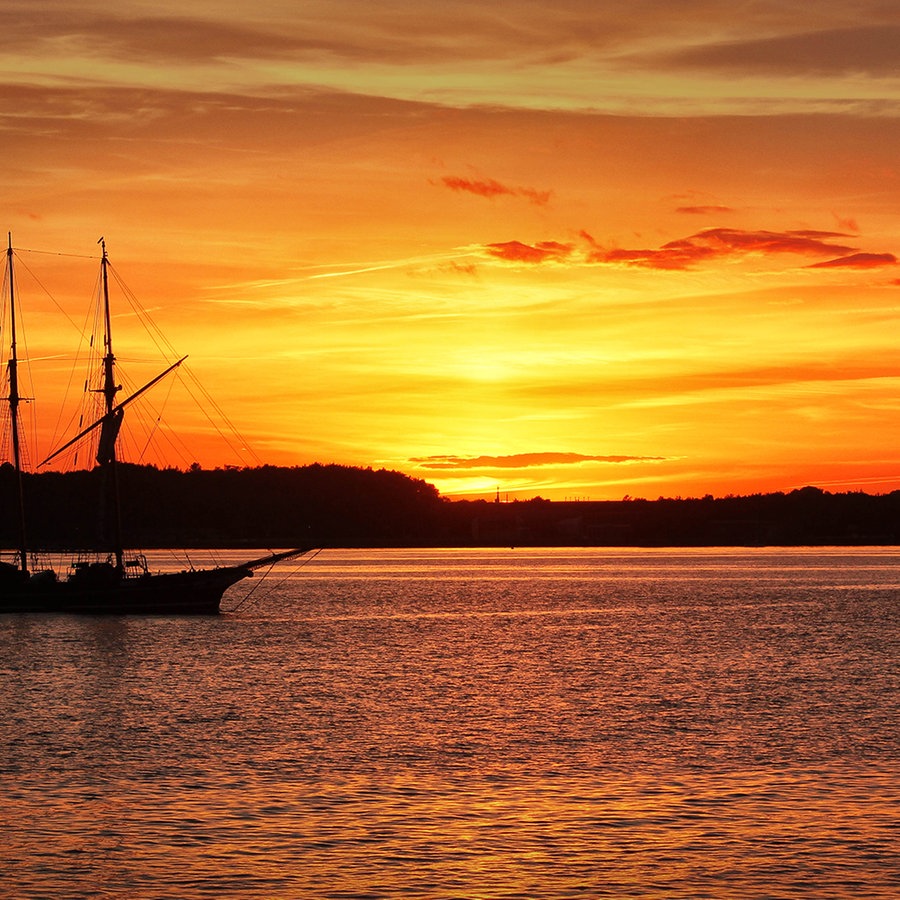 Kieler Förde bei Sonnenuntergang. Ein Segelschiff fährt gerade wieder ein. © Uwe Reimer Foto: Uwe Reimer