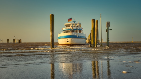 Ein Schiff am Anleger bei aufgehender Sonne. © Reinhard Wehrenbrecht Foto: Reinhard Wehrenbrecht