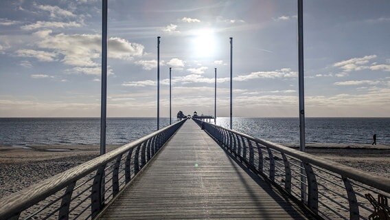 Sonnenschein und wenige Wolken am Himmel über einer Seebrücke an der Ostsee. © Wilhelm Brandenburg Foto: Wilhelm Brandenburg