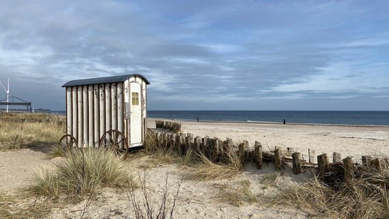 Eine kleine Holzhütte steht am Strand von Damp, im Hintergrund ist die Ostsee. © Ines Eiermann Foto: Ines Eiermann