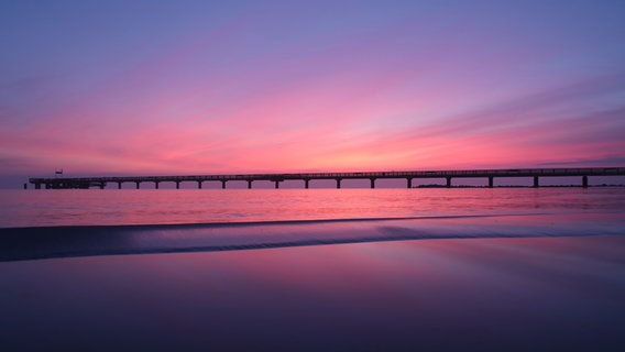 Die Seebrücke am Schönberger Strand im rosanen Morgenlicht. © Kristina Schröder Foto: Kristina Schröder