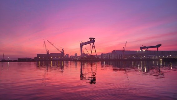 Rosanes Morgenlicht am Himmel über den Werftkränen in Kiel. © Nadine Pudimat Foto: Nadine Pudimat