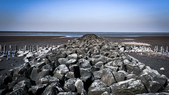 Eine Steinbarrikade am Strand bei Sonnenschein mit Blick aufs Meer. © Christian Lau Foto: Christian Lau