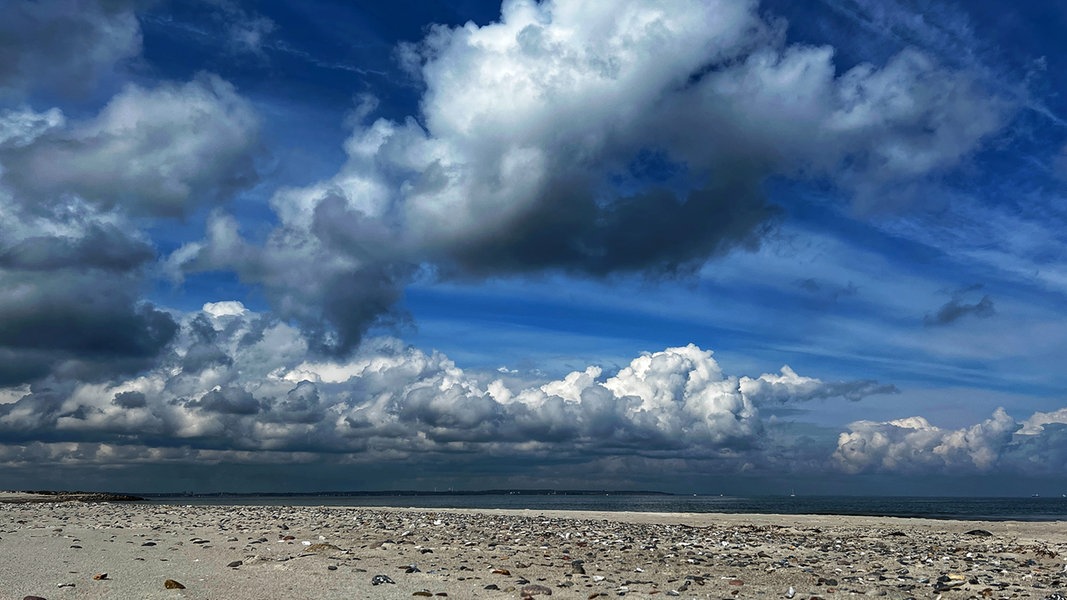 Ein Himmel voller Wolken über dem Strand des Naturschutzgebietes Bottsand mit Blick auf die Förde.