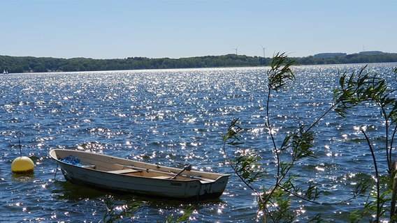 Ein kleines Boot auf einem See, der durch die Sonne glitzert. © Brigitte Sibbe Foto: Brigitte Sibbe