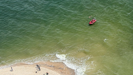 Extremschwimmer André Wiersig schwimmt neben einem Rettungsboot auf seiner letzten und schwersten Etappe von Amrum nach Sylt. © Stefan Gaul Foto: Stefan Gaul
