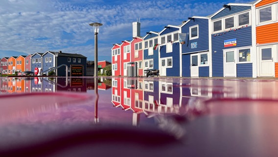 Bunte Häuser auf Helgoland spiegeln sich im Wasser. © Raphael Deusing Foto: Raphael Deusing