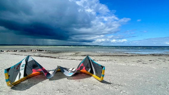 Ein bunter Kiteschirm liegt auf dem Strandsand, bevor er in die Luft steigt. © Maike Zielke Foto: Maike Zielke