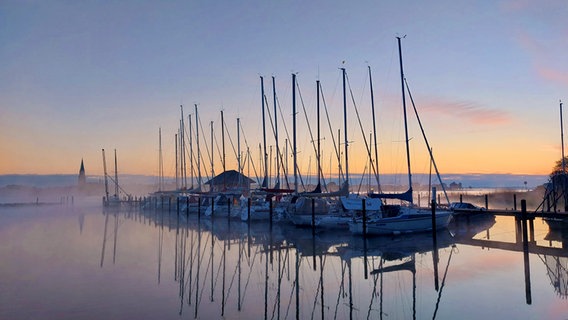 Die Sonne geht über dem Haddabyer Hafen auf und färbt den Himmel ein. © Ines Buhmann Foto: Ines Buhmann