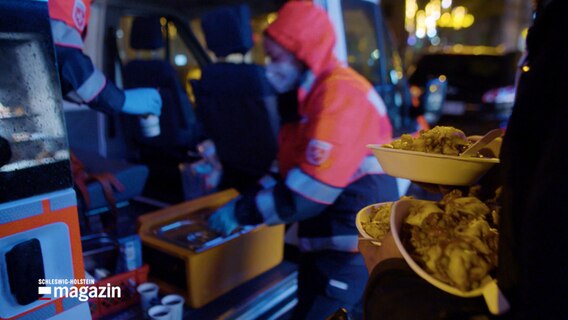 Eine obdachlose Person bekommt an einem Kältebus eine warme Mahlzeit. © NDR 