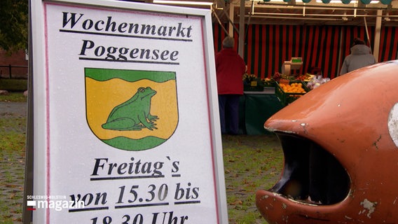Ein Schild weisst auf den Wochenmarkt in Poggensee hin. Freitags zwischen 15:30 und 18:30 Uhr © NDR Foto: NDR Screenshots