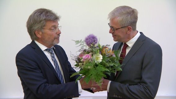 Der parteilose Claudius Teske (rechts) bekommt zur Wahl zum Landrat einen Blumenstrauß überreicht. © NDR 