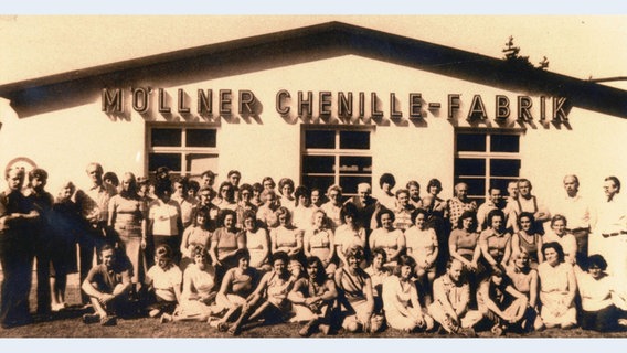Auf einer alten Aufnahme sieht man, wie zahlreiche Menschen vor der Möllner Chenille Fabrik stehen. © NDR 