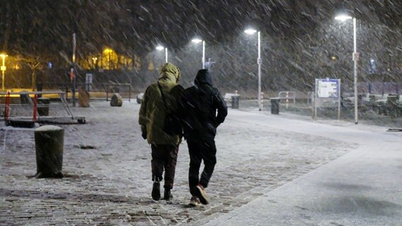Zwei Menschen laufen durch das verschneite Flensburg. © Sebastian Iwersen Foto: Sebastian Iwersen