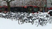 Schneebedeckte Fahrraäder am Kieler HBF. © NDR 