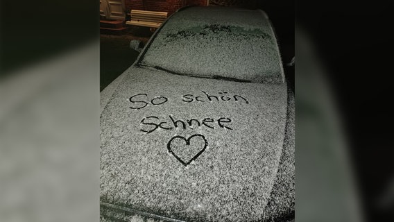 Auf einer Motorhaube steht "So schön Schnee" in den Schnee geschrieben. © Katja Heuer Foto: Katja Heuer