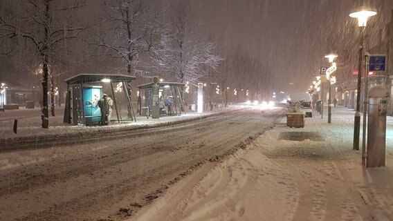Personen warten an einer verschneiten Straße an der Bushaltestelle auf Ihren Bus. © Lukas Knauer Foto: Lukas Knauer