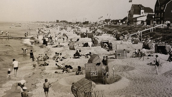 Das historische Bild zeigt den Strand von Schönberg voller Badegäste, die um die zahlreichen Strandkörbe kleine Wälle gebaut haben. © Projekt Spurensuche 