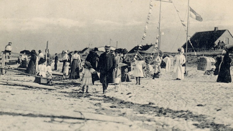 Das historische Bild zeigt den Strand von Schönberg mit Gästen, die sehr schick angezogen sind. © Projekt Spurensuche